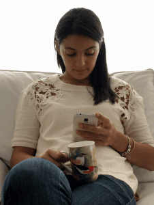 millennial woman interacting with her cellphone and checking emails while sitting on a living room sofa nip 2gzcx F0000 e1553626928729