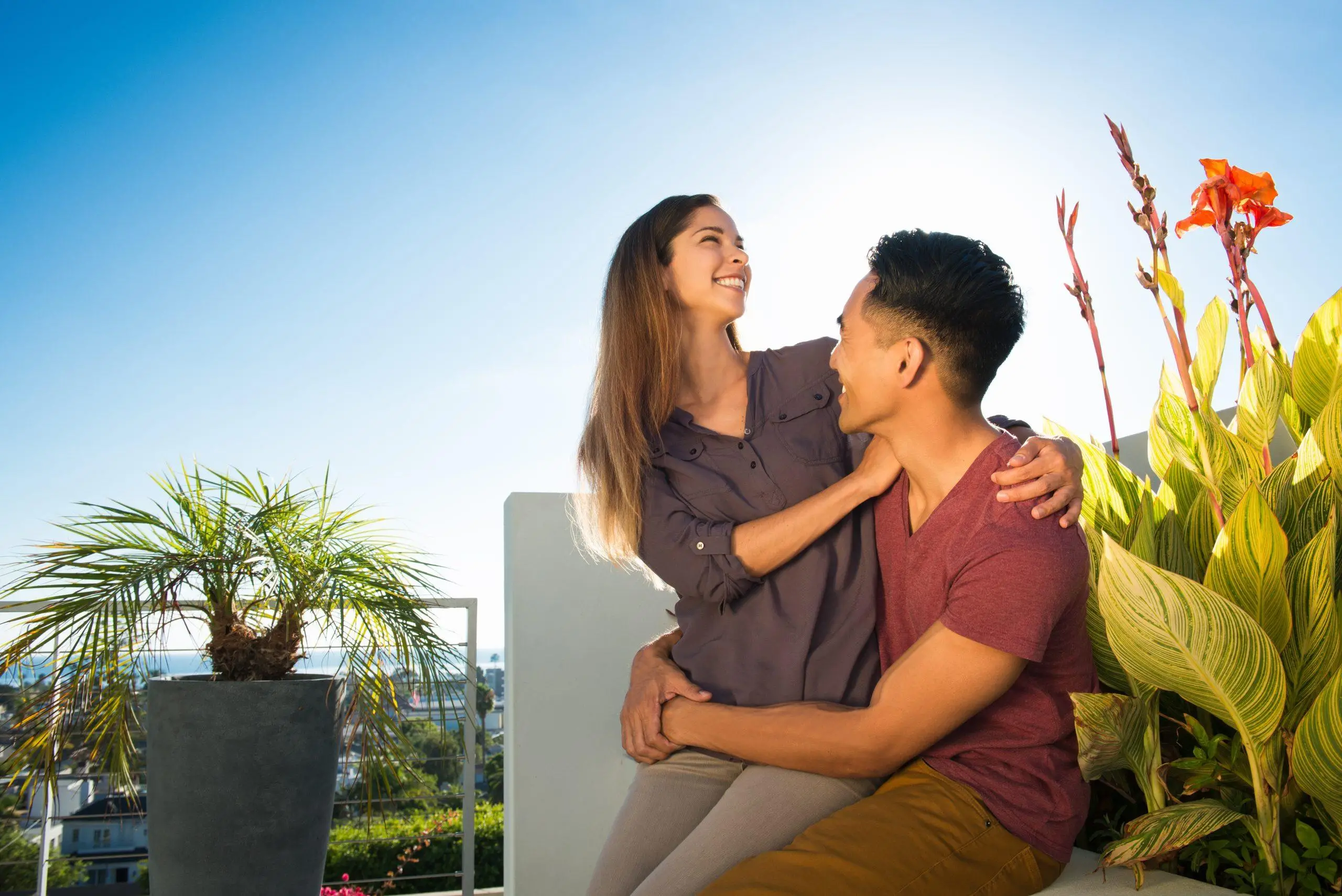 Couple with arms around each other in penthouse rooftop garden