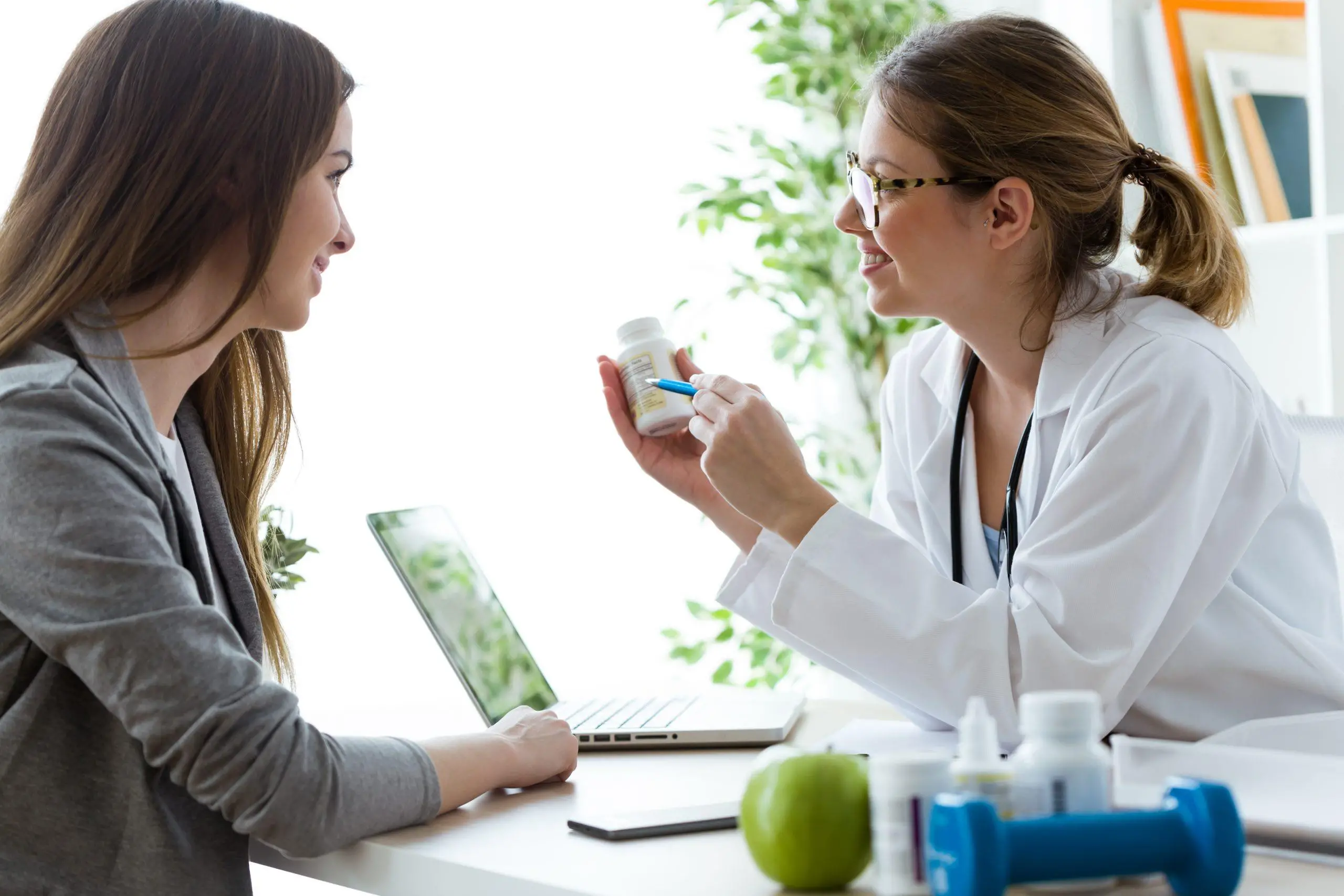 Shot of female dietician prescribing nutritional supplement for patient in the consultation.