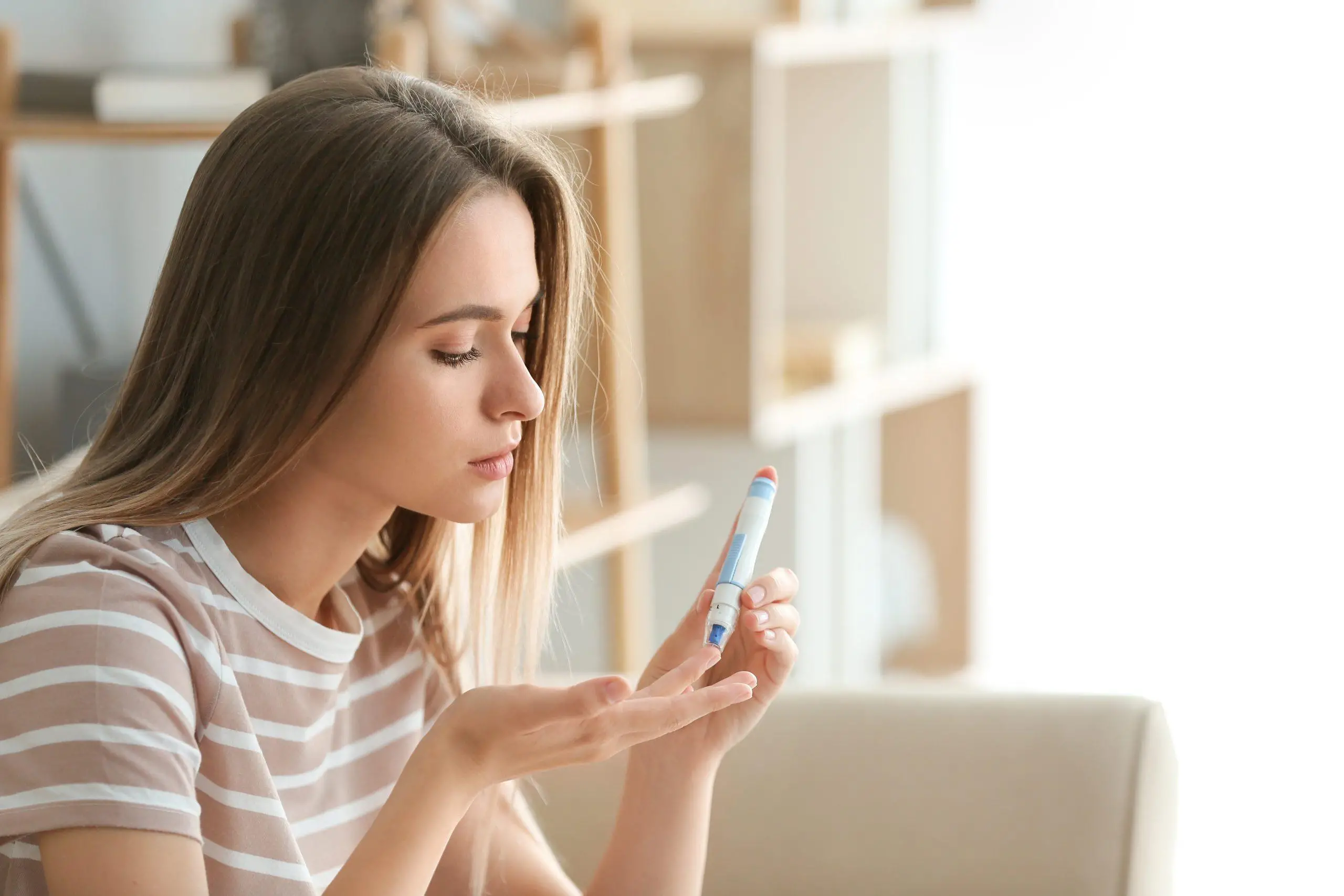 Diabetic woman checking blood sugar level at home
